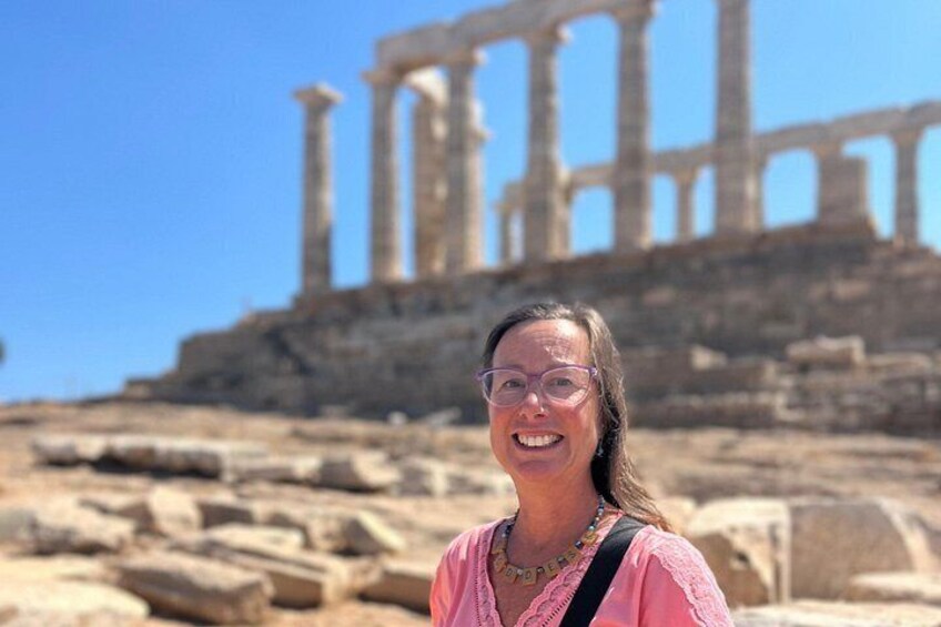 A person standing in front of ancient ruins with columns. 5