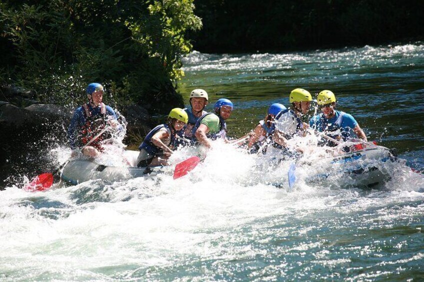 A group of people in a white raft navigating a river. 4