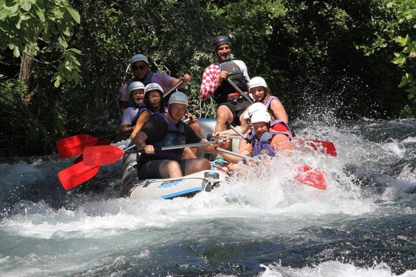 A group of people in a raft navigating a river. 2