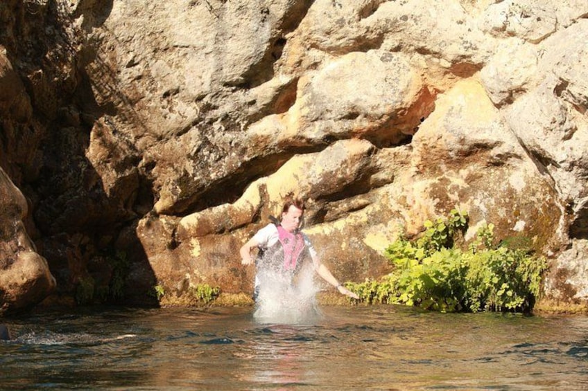 Una persona vadea un río en un cañón rocoso. 2