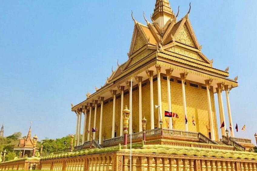 A golden temple with a pointed roof and multiple flags. 1