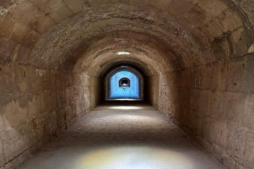 En stentunnel med en blå dörr i slutet. 5