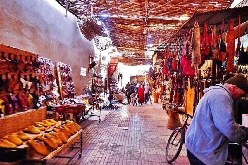 A market with various stalls selling goods, a person on a bicycle, and a crowd in the background. 4