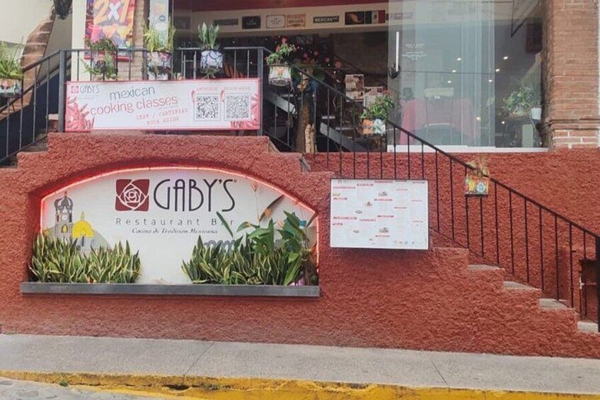 Un restaurant appelé Gaby, avec une enseigne, un escalier et un mur en briques rouges. 3