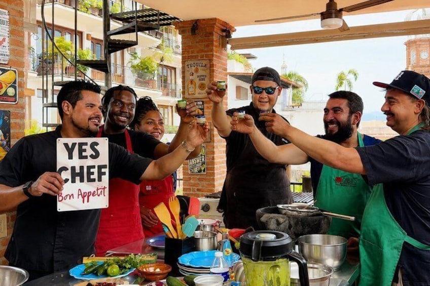 Un gruppo di persone a un banco gastronomico con un cartello che recita 'YES CHEF Bon Appetit'. 2