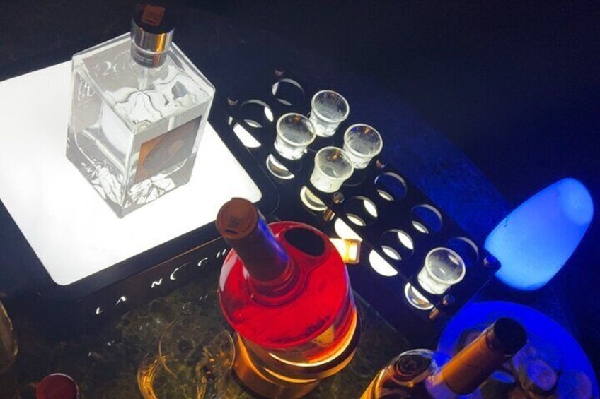 Een bar met drank, shotglazen en verlichting. 5