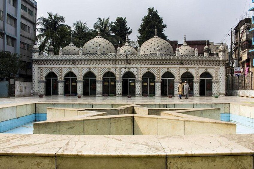 A mosque with domed roofs and arched doorways, surrounded by a courtyard with a pool. 2