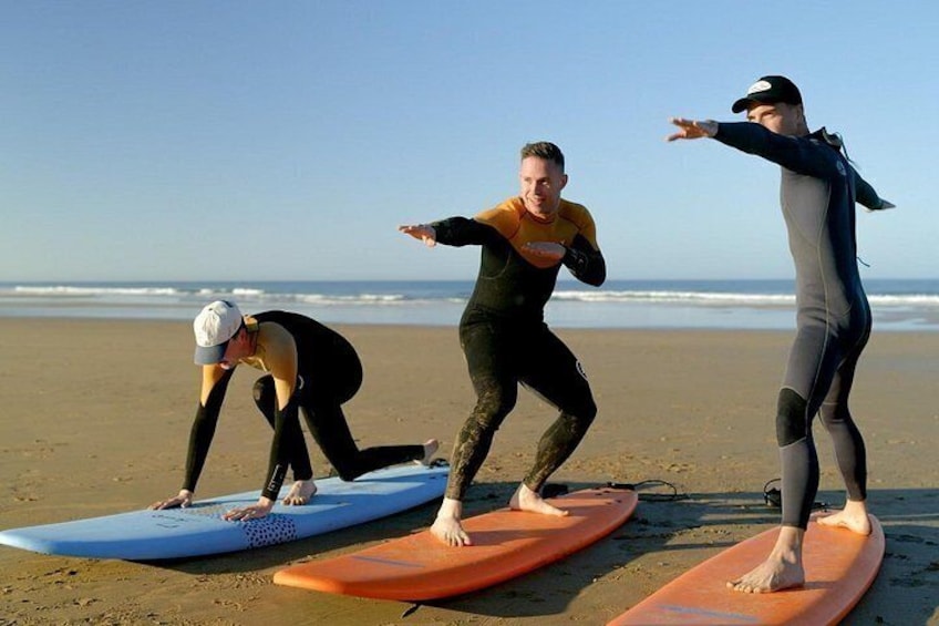 Three people on surfboards at the beach. 4