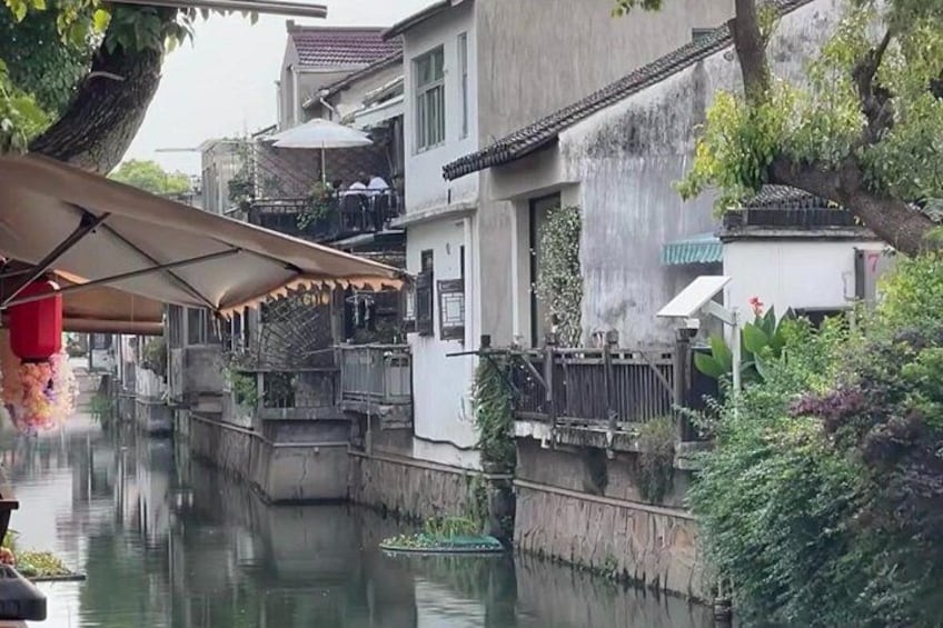 Un canale stretto fiancheggiato da edifici, una copertura e vegetazione rigogliosa. 2