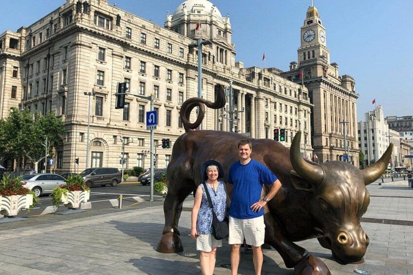 Una statua di toro, un edificio grande con una cupola e una torre dell'orologio. 5