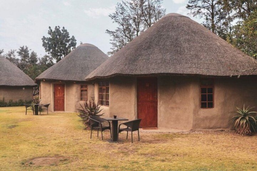 Thatched-roof huts with a thatched roof, a red door, and a small window. 4