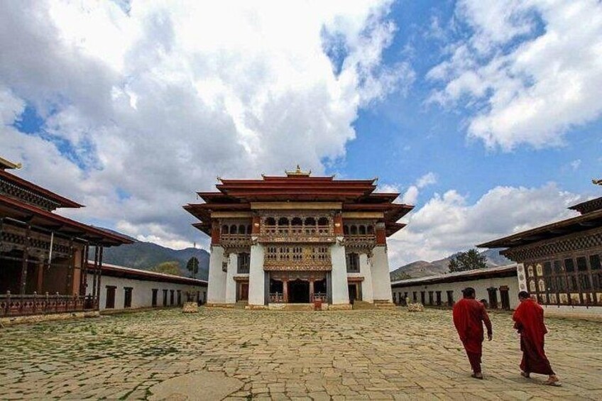 A traditional building with a tiered roof, surrounded by a courtyard with a cobblestone ground. 5