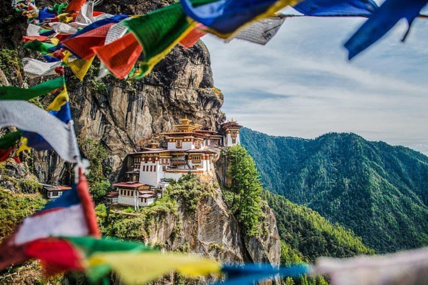 A monastery perched on a cliff, surrounded by lush greenery and mountains. 3