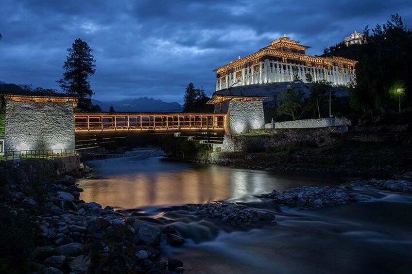 A bridge over a river at night with a traditional building on the right. 2