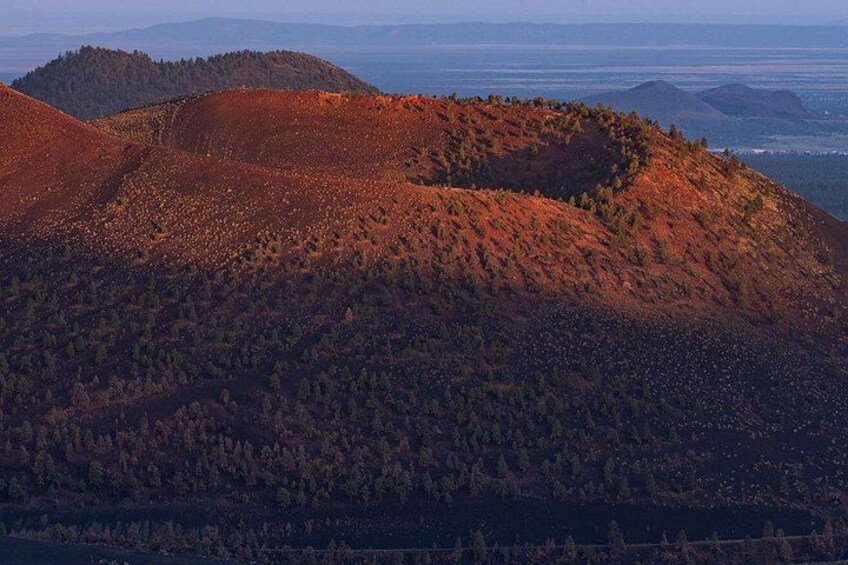 A mountainous landscape with dense forest coverage and rolling hills. 3