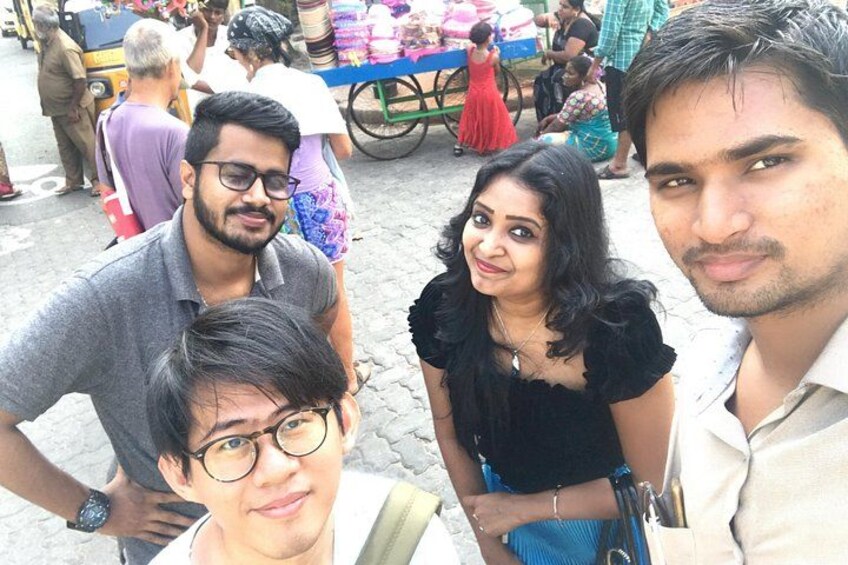 A group of people in an outdoor market with a cart and various goods. 4