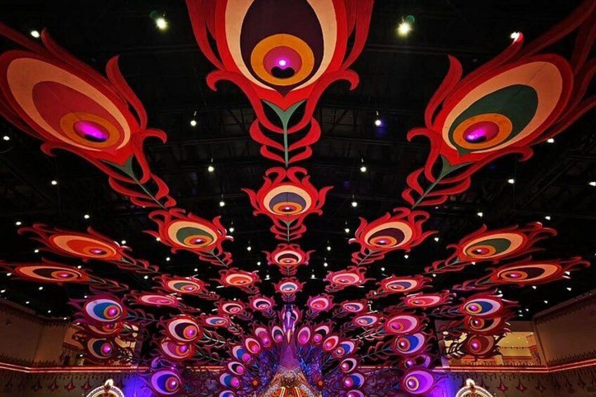 A ceiling with a symmetrical, colorful peacock design. 2