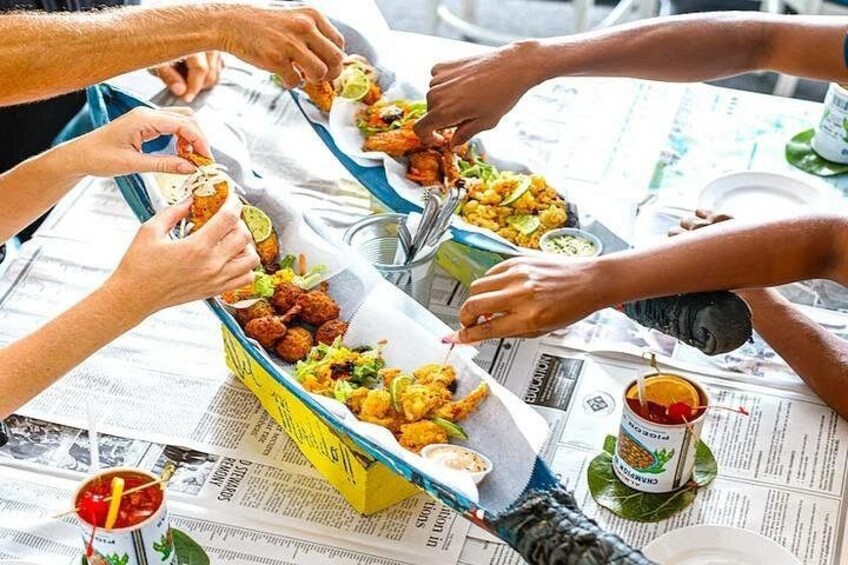 People eating at a table with food containers and newspapers. 3