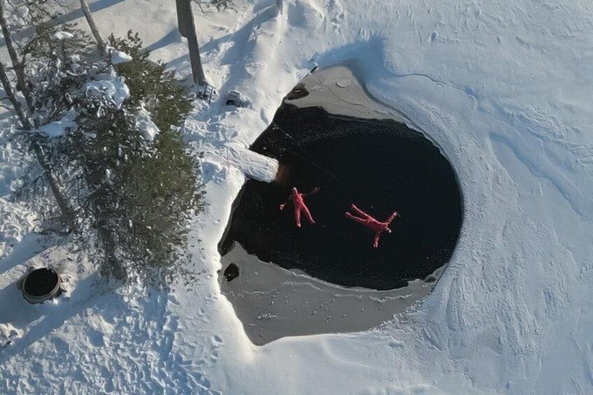 Ett snötäckt landskap med ett stort hål i marken, omgivet av snö och träd. 1