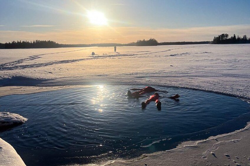 En frusen sjö där folk åker skridskor och en person fiskar genom isen. 5