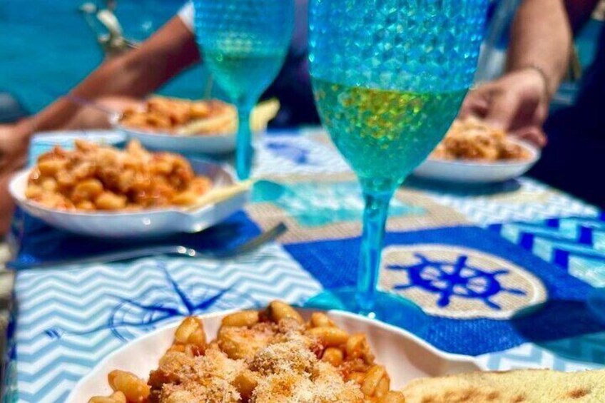 A table with food, a glass of drink, and a Star of David pattern on the tablecloth. 3