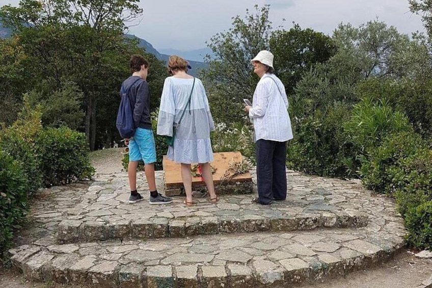 Drie personen staan op een stenen platform met uitzicht op het landschap. 5