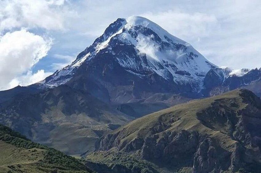 A snow-capped mountain with a valley in the foreground. 1