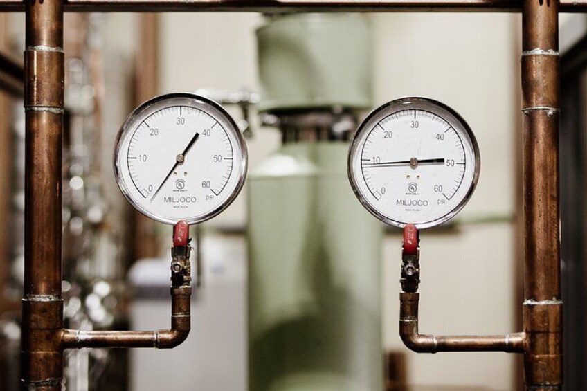 Two pressure gauges mounted on a metal frame, connected by pipes. 2