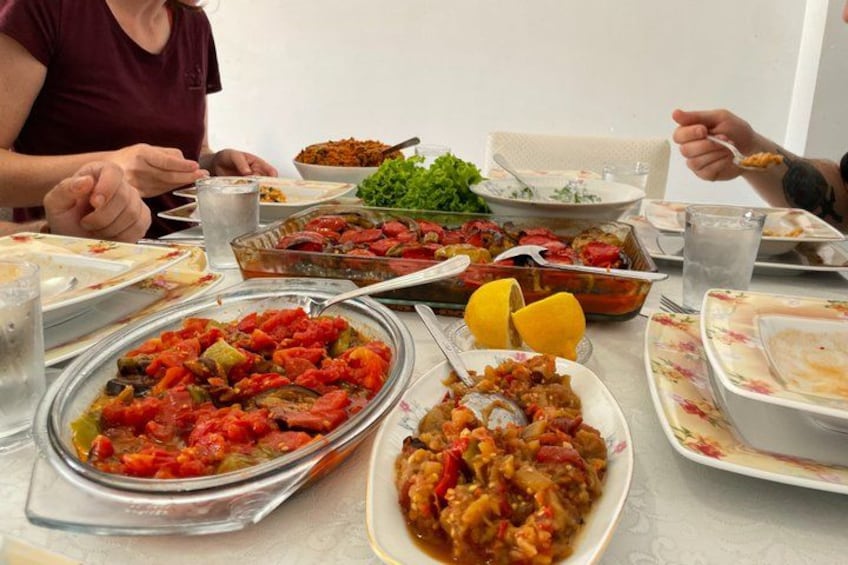 A table with various dishes, including a large bowl of stew and several plates with food. 2