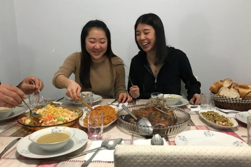 A dining table with various dishes, including a bowl of soup, a plate of food, and a basket of bread. 3