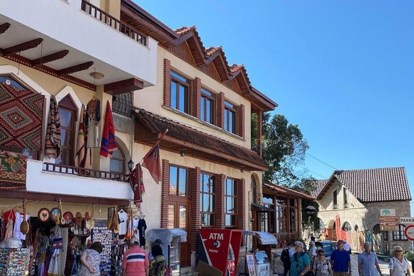 A traditional building with balconies, flags, and a shop with various items on display. 1
