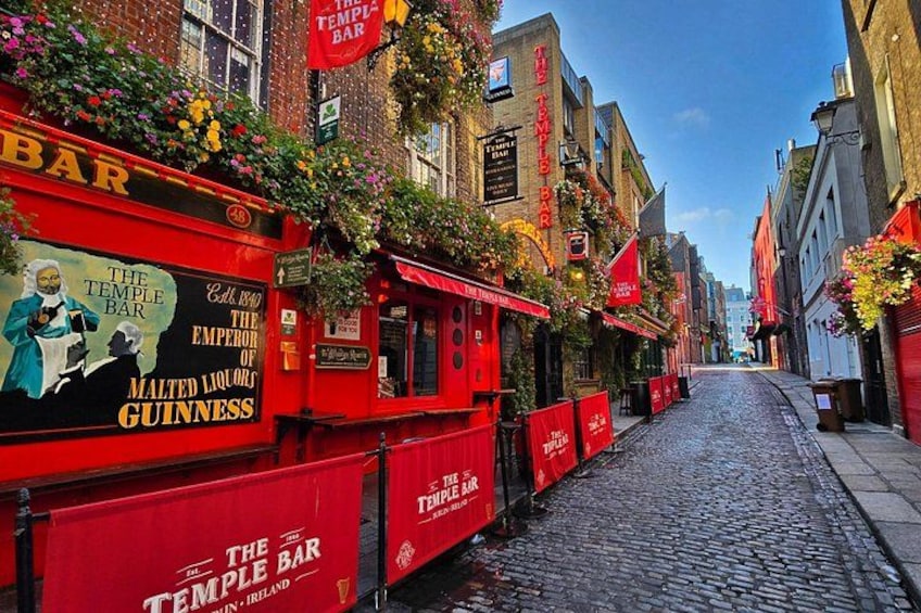 A cobblestone street lined with red buildings, one of which is labeled 'The Temple Bar.' 4