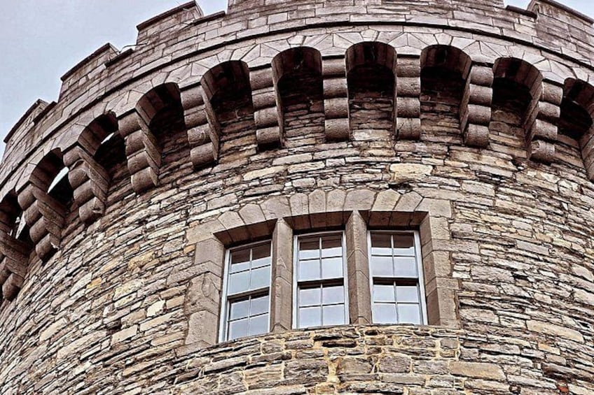 A stone tower with arched windows and battlements. 3