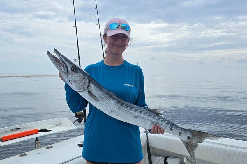 A person holding a large fish on a boat. 2