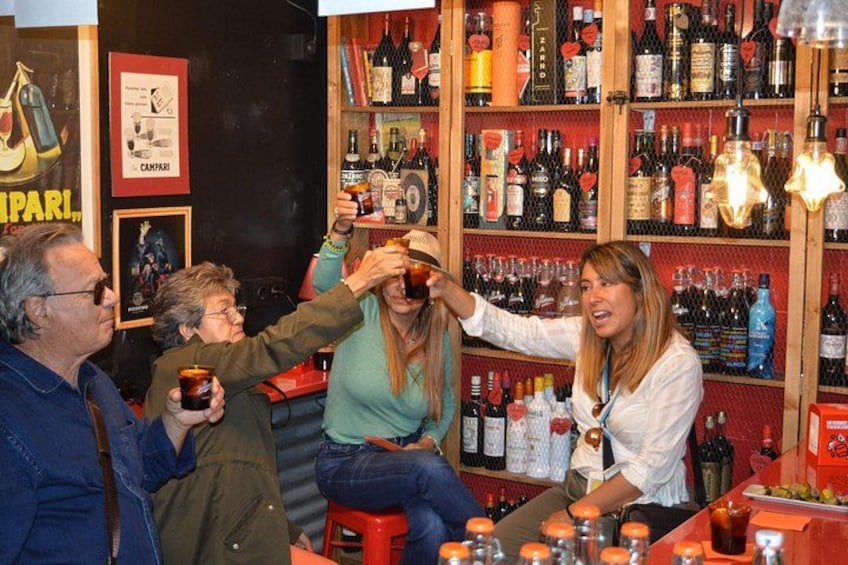 Een bar met flessen op planken en iemand die een drankje inschenkt. 5