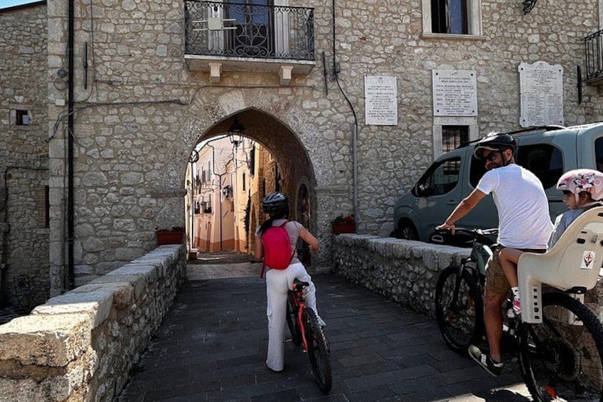 A stone archway, a narrow street, and a parked van. 5