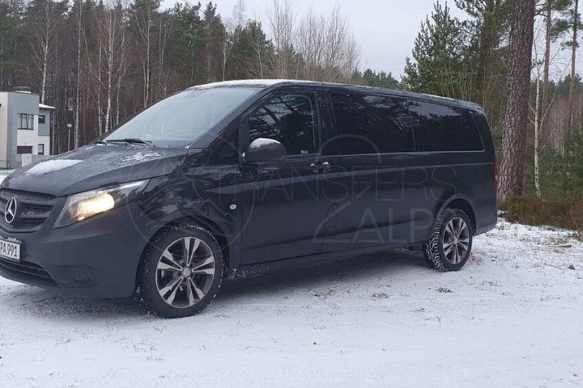 En sort varevogn parkeret på et snækkedække med træer i baggrunden. 5