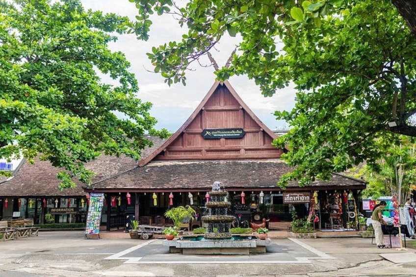A traditional wooden building with a pointed roof, surrounded by lush green trees. 5