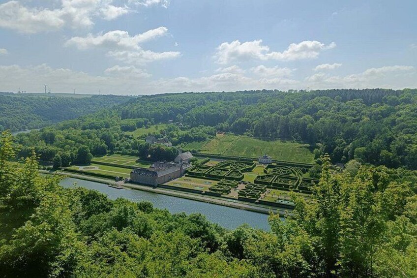 Un paysage verdoyant et luxuriant, avec une rivière, un grand bâtiment et un jardin bien entretenu. 3