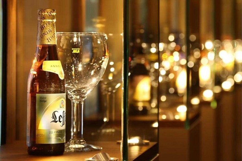 A bottle of Seifert Blond beer and an empty glass on a table with a blurred background of lights. 4