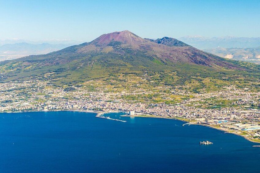 Una ciudad costera con una montaña destacada al fondo. 2