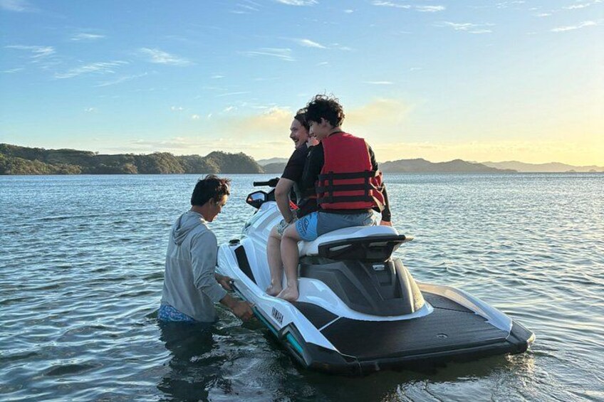 Une personne sur un jet ski, évoluant sur une étendue d'eau, avec un paysage montagneux en arrière-plan. 1