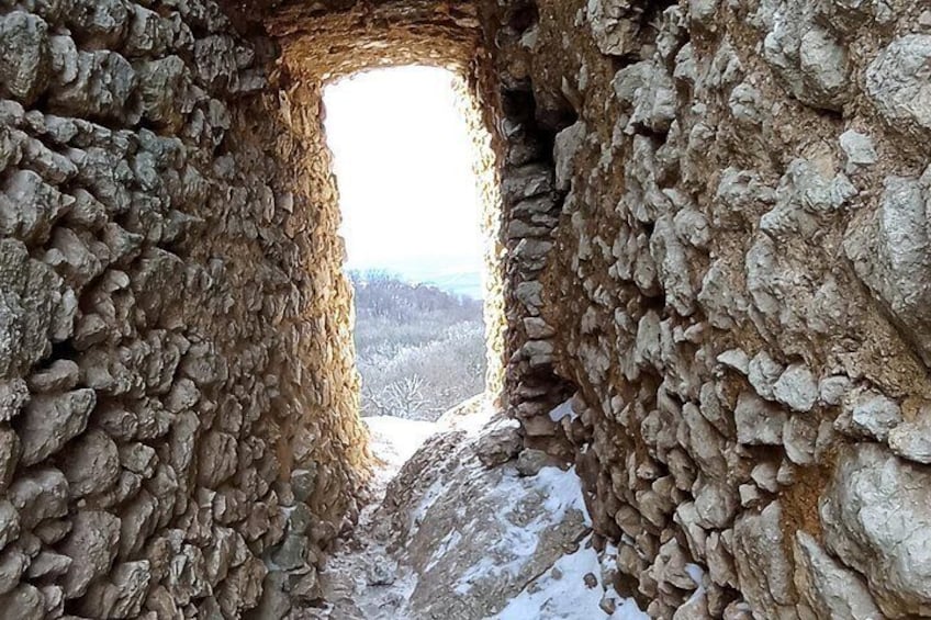 A stone archway with a snowy landscape in the background. 3