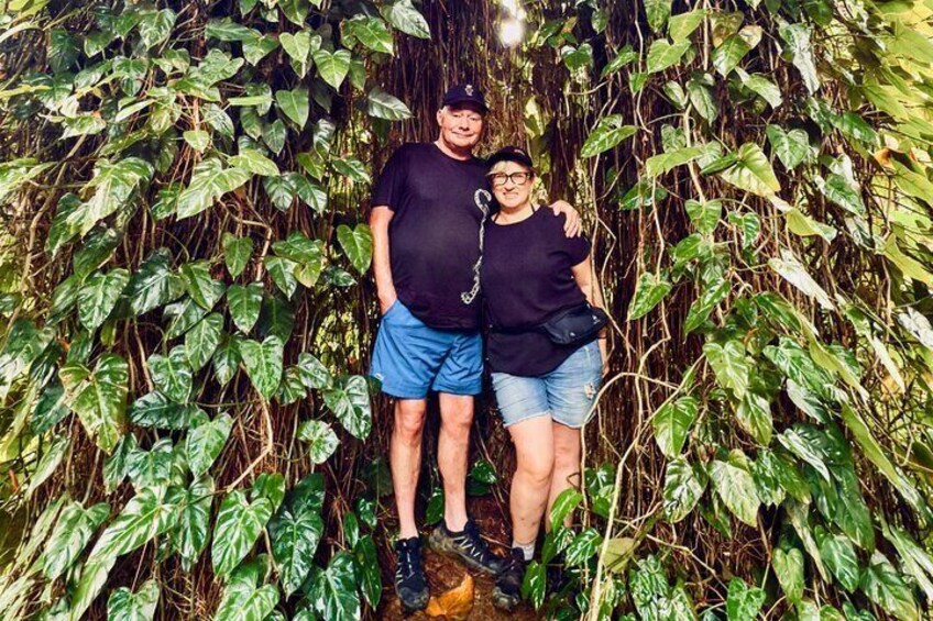 Dos personas de pie en una zona verde exuberante, con follaje denso. 4