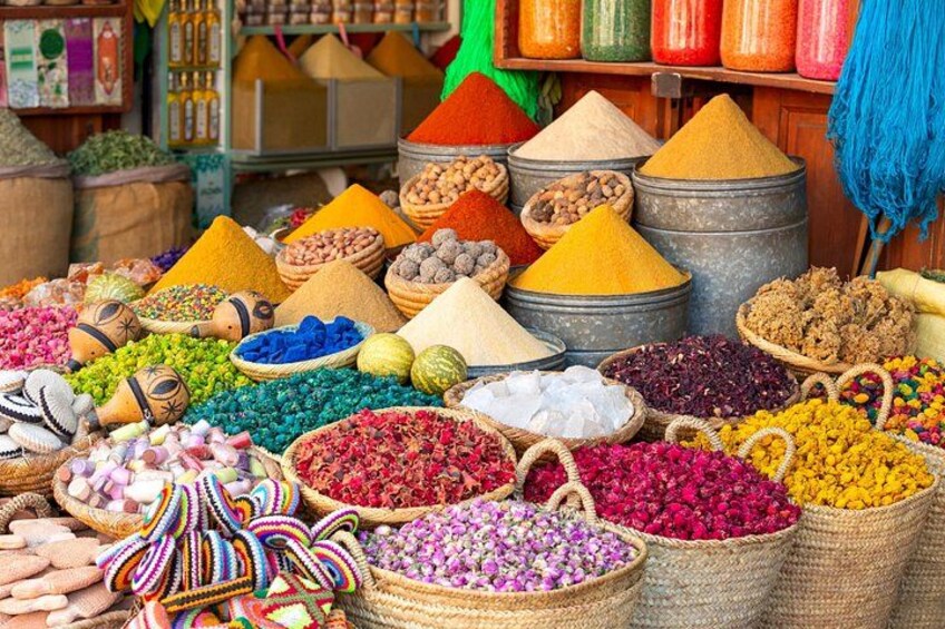 A market with various colorful spices and grains displayed in baskets and cones. 5