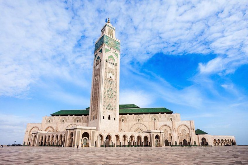 A large mosque with a tall minaret and a green roof. 4