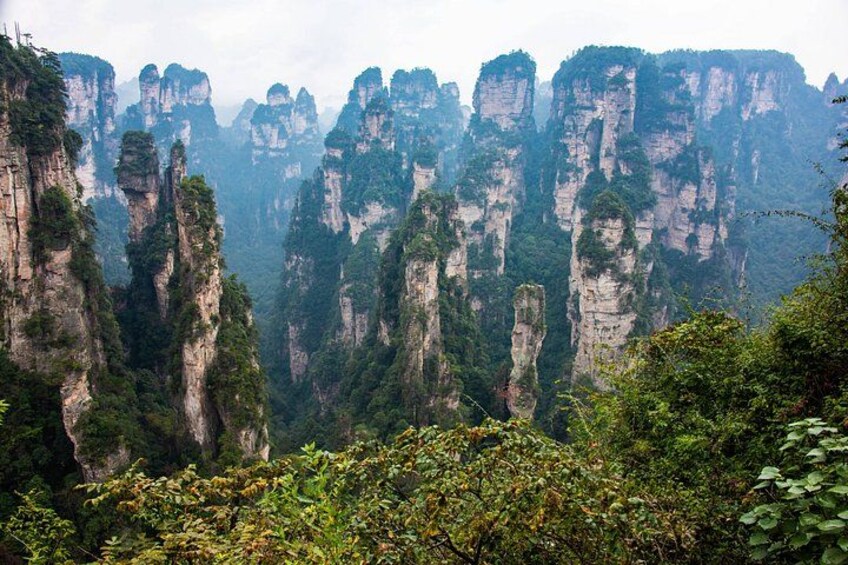 A mountainous landscape with towering rock formations and dense greenery. 2