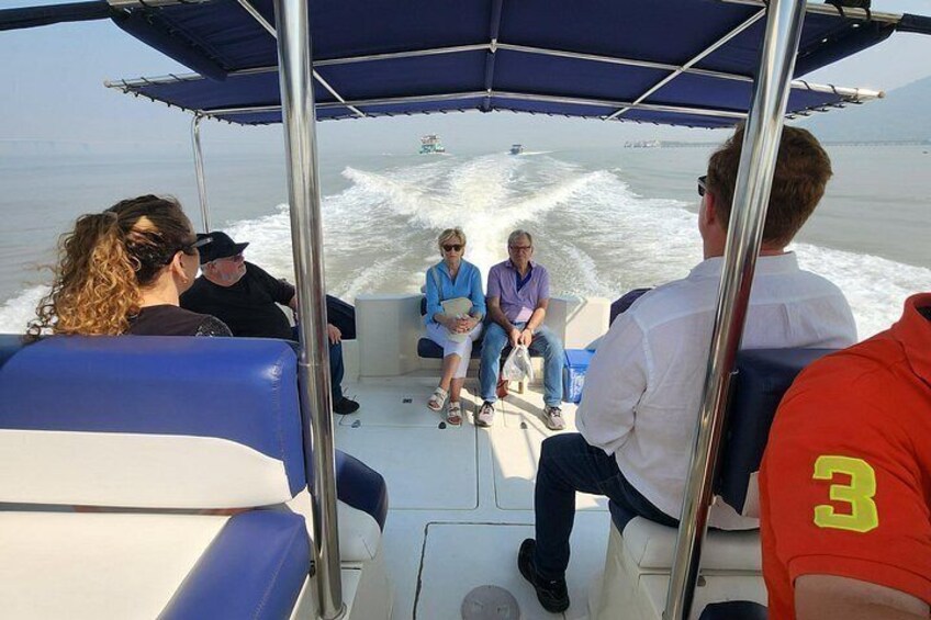 A group of people on a boat with a wake behind it. 2