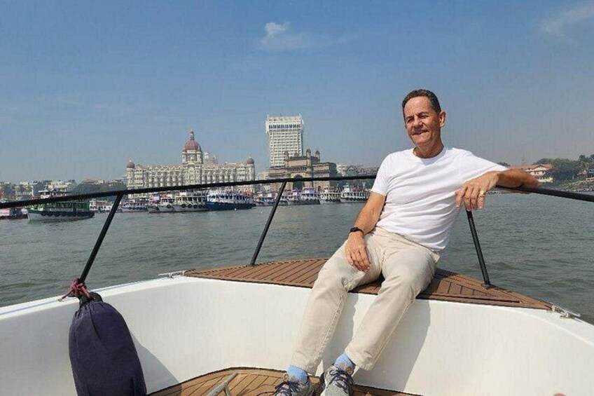 A person sitting on a boat with a cityscape in the background. 4