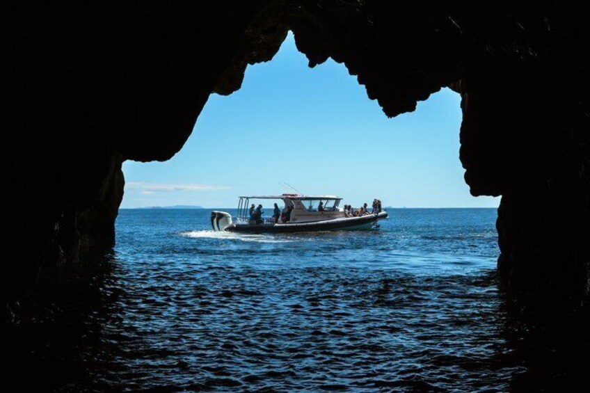 A boat in a cave opening with calm water. 3
